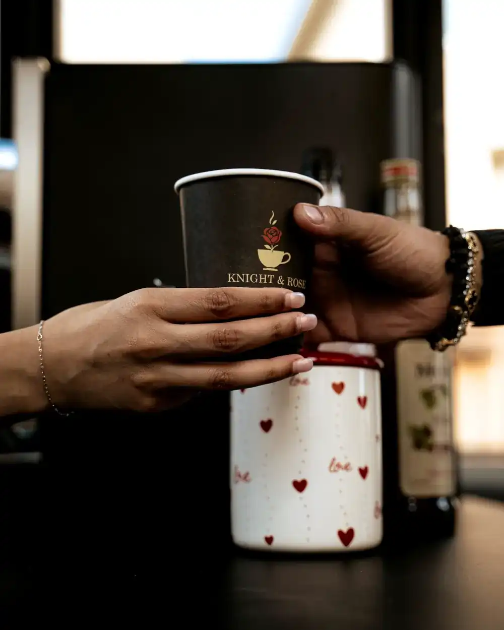 A barista handing over a Knight & Rose cup at an event.