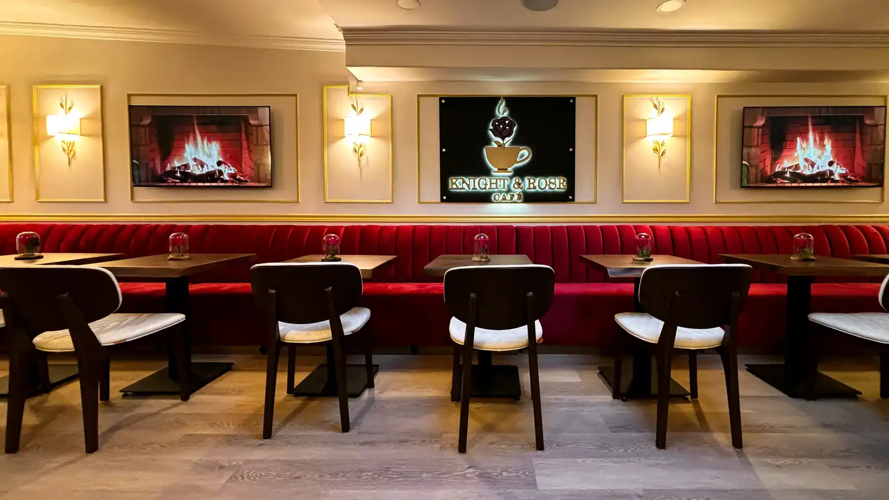 The Knight and Rose dining room, red velvet banquettes and walnut tables running the length of the second floor under brass sconces.
