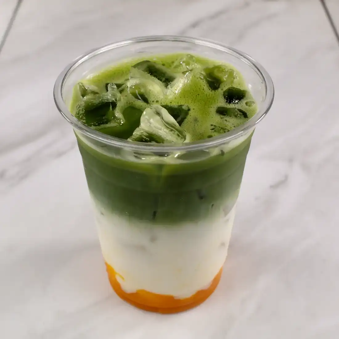 Fusion matcha at Knight & Rose Café — ceremonial matcha layered over cream and mango purée in a tall glass.